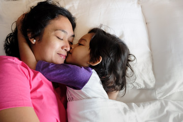 Southeast Asian Boy Showing His Love, Hugging and Kissing His Mother while Still on Bed In The Morning. Asian Ethnicity Domestic Lifestyle
