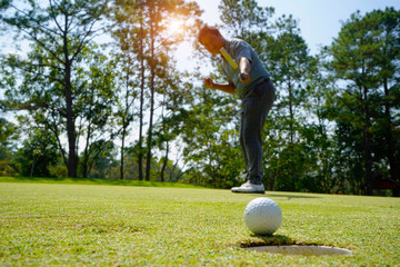 Blurred golfer playing golf in the evening golf course, on sun set evening time.