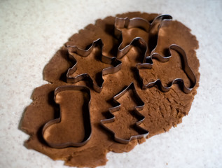 Gingerbread cookies cutters on rolling dough: star, cat, bear, christmas tree and santa boot. Preparations of row dough in xmas time. Homemade baking. Healthy food without sugar with honey only.