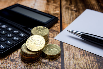 Close up gold coins, calculator, pen, notebook on wooden table. Business, finance, marketing, e-commerce concept and design