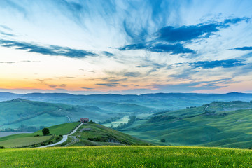 Fototapeta premium Italian valley in the dawn light with a house on a hill