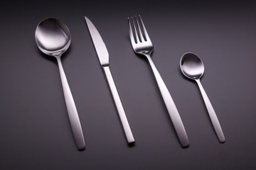 Shiny cutlery over a black background