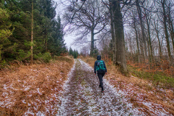 hiker walking along trail in winter in mountains