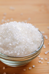 sugar in glass bowl on wooden background 