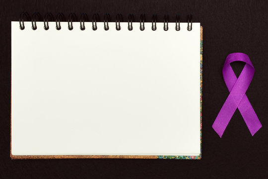 Purple ribbon for text World Cancer Day Awareness, symbolic bow color raising awareness on people living with women's breast tumor illness. bow isolated with clipping glitter blue background