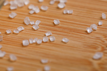 sugar in glass bowl on wooden background 