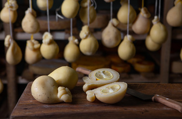 Sliced head of Italian hard cheese Scamorza or Caciocavallo with lime. caciocavallo - Italian cheese made from cow's or sheep's milk, closeup.