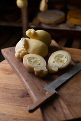 Sliced head of Italian hard cheese Scamorza or Caciocavallo with lime. caciocavallo - Italian cheese made from cow's or sheep's milk, closeup.
