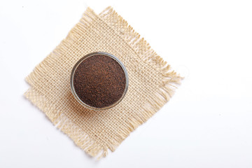 dry tea in glass bowl with lemon and ginger over white background 