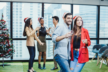 Obraz premium Couple office workers celebrating with drink wine together in the company.