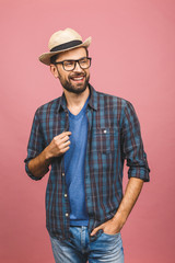 Picture of happy young man standing isolated over pink background. Looking at camera.