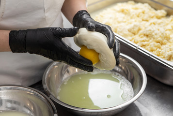 Italian hard cheese silano or caciocavallo in cheesemaker hands. The home-made cheese maker...