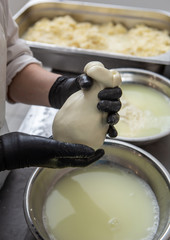 Italian hard cheese silano or caciocavallo in cheesemaker hands. The home-made cheese maker produces handmade caciocavallo. Concept: tradition, italy, mozzarella.The process of making mozzarella.