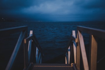 Wooden staircase leading to the ocean at Wellington Harbour, New Zealand