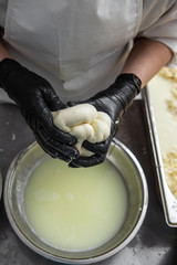 Fototapeta na wymiar Italian hard cheese silano or caciocavallo in cheesemaker hands. The home-made cheese maker produces handmade caciocavallo. Concept: tradition, italy, mozzarella.The process of making mozzarella.