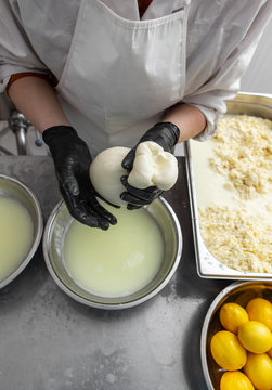 Italian hard cheese silano or caciocavallo in cheesemaker hands. The home-made cheese maker produces handmade caciocavallo. Concept: tradition, italy, mozzarella.The process of making mozzarella. 
