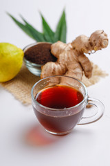Black tea with lemon and ginger over white background 