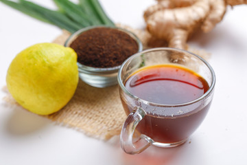 Black tea with lemon and ginger over white background 