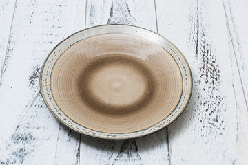 Plate on white scraped wooden background side view