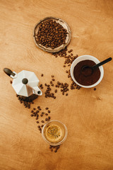 Roasted coffee beans, grounded coffee, geyser maker and espresso in glass - flat lay of making coffee. Alternative coffee brewing concept. Coffee maker, aromatic beans, espresso