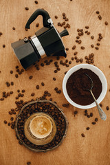 Flat lay of making alternative coffee. Roasted coffee beans, grounded coffee, geyser maker, espresso in glass. Coffee brewing concept. Coffee maker, aromatic beans, espresso on wooden table