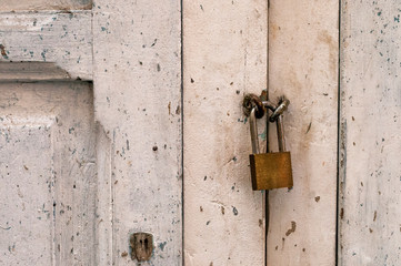 Old metal lock on a white wooden door