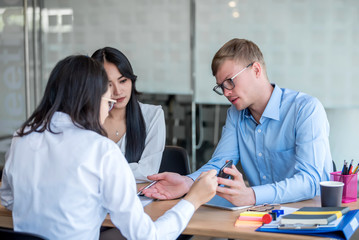 Obraz premium Business people gather to analyze marketing and investment information and using pen pointing to financial data chart at meeting.