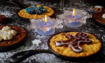 Christmas dinner table with burning candles, glasses and four mini pie.