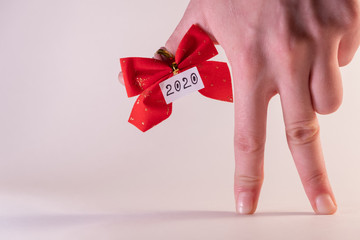 Female fingers mimic the gait of a person, show the inscription 2020. Creative idea for the New...