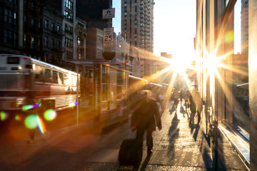 Fototapeta na wymiar Man rushing down the sidewalk in Manhattan New York City with bright light in the background