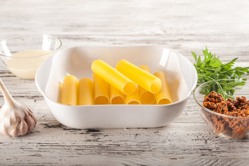 The process of making pasta. Raw cannelloni pasta on a light table close-up and copy space.