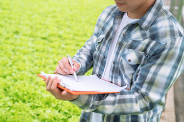 Farmers take care and monitor the growth of vegetables in the organic garden, Modern technology,...