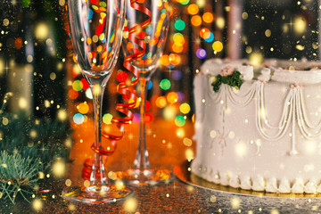 Christmas and New Year celebration concept. Champagne, glasses and holiday cake near the Christmas tree with decorations