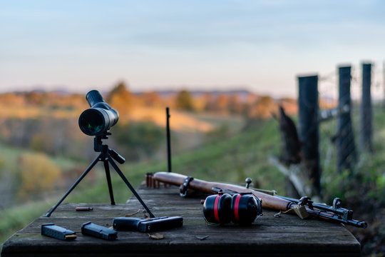 spotting scope hearing protection pistol/handgun and rifle on table at outdoor gun range in Kentucky