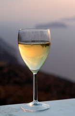 An isolated wine glass, filled with chilled white wine.  Taken on the island of Sikinos in Greece.  A bokeh background provides copy space and emphasises the foreground and subject mater.