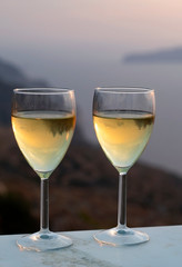 Two glasses with chilled white wine.  Taken on the island of Sikinos in Greece.  A bokeh background provides copy space and emphasises the foreground and subject mater.