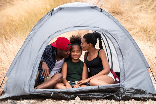 Happy Family Mixed Race Be Loving Child Inside Tent On Camping Hoilday At Yellow Grass Field. Camping Concept.