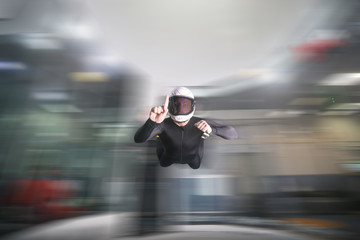 One finger. Fly men show one finger. Sky diver in black suit. Teampleat skydiver.