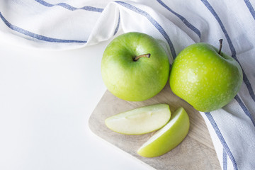 Ripe green apples and apple slices on white background, top view