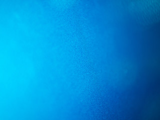 Fototapeta na wymiar Blue metallic car paint blurred shiny background with bokeh effect
