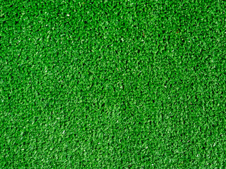 Flat lay artificial grass made of green synthetic fibers. Top view evergreen lawn background