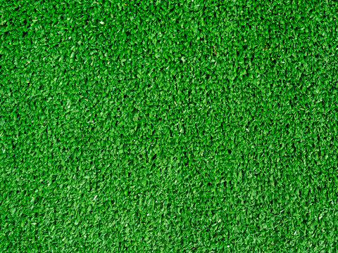 Flat lay artificial grass made of green synthetic fibers. Top view evergreen lawn background