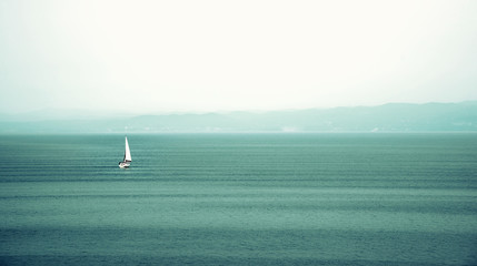 Abstract landscape with a lonely sailing boat in the midst of the boundless sea (loss of landmarks,...
