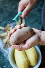 closeup of a hand holding a raw potato