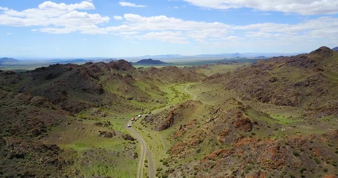 cars drive along a mountain road to a gorge in the mountains of Mongolia