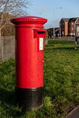 Fototapeta na wymiar A classic vintage red mailbox for posting letters in a Street in Wales, United Kingdom