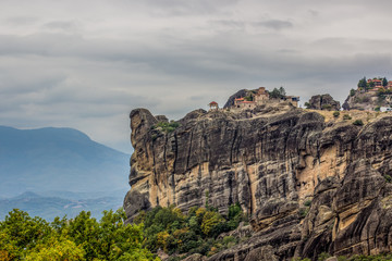 Christian highland monastery ancient building on top of rock mountain picturesque scenic view far from civilization in atmosphere moody cloudy weather time 
