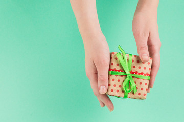 Present in woman hand on a green background.