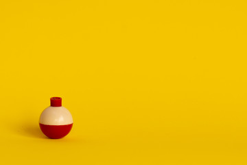 fishing float buoy on a yellow background with copy space