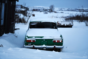 old cars under the snow in the Russian Arctic